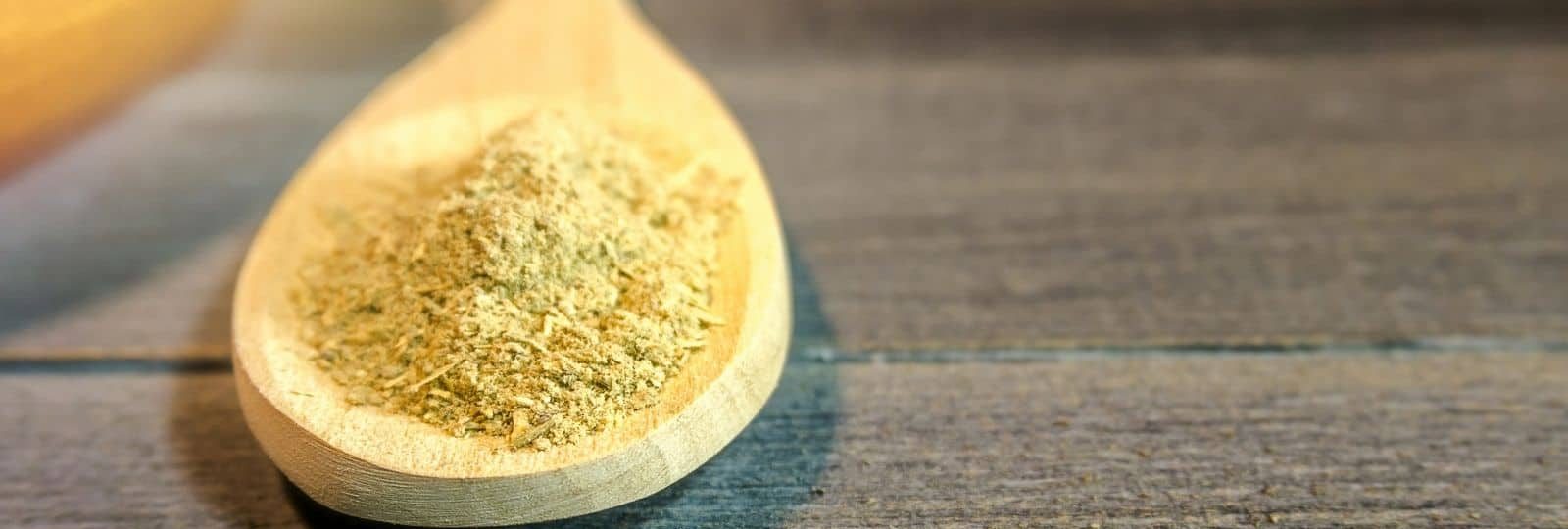 Ground kava root powder on a wooden spoon